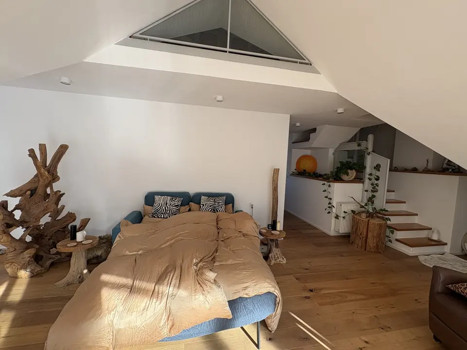 Hauptraum im Raum Landshut mit ausgeklapptem Schlafsofa unter dem Giebelfenster