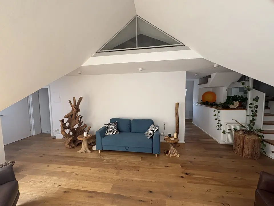 Wohnbereich im Hauptraum von Raum Landshut mit Sofa unter dem Giebelfenster